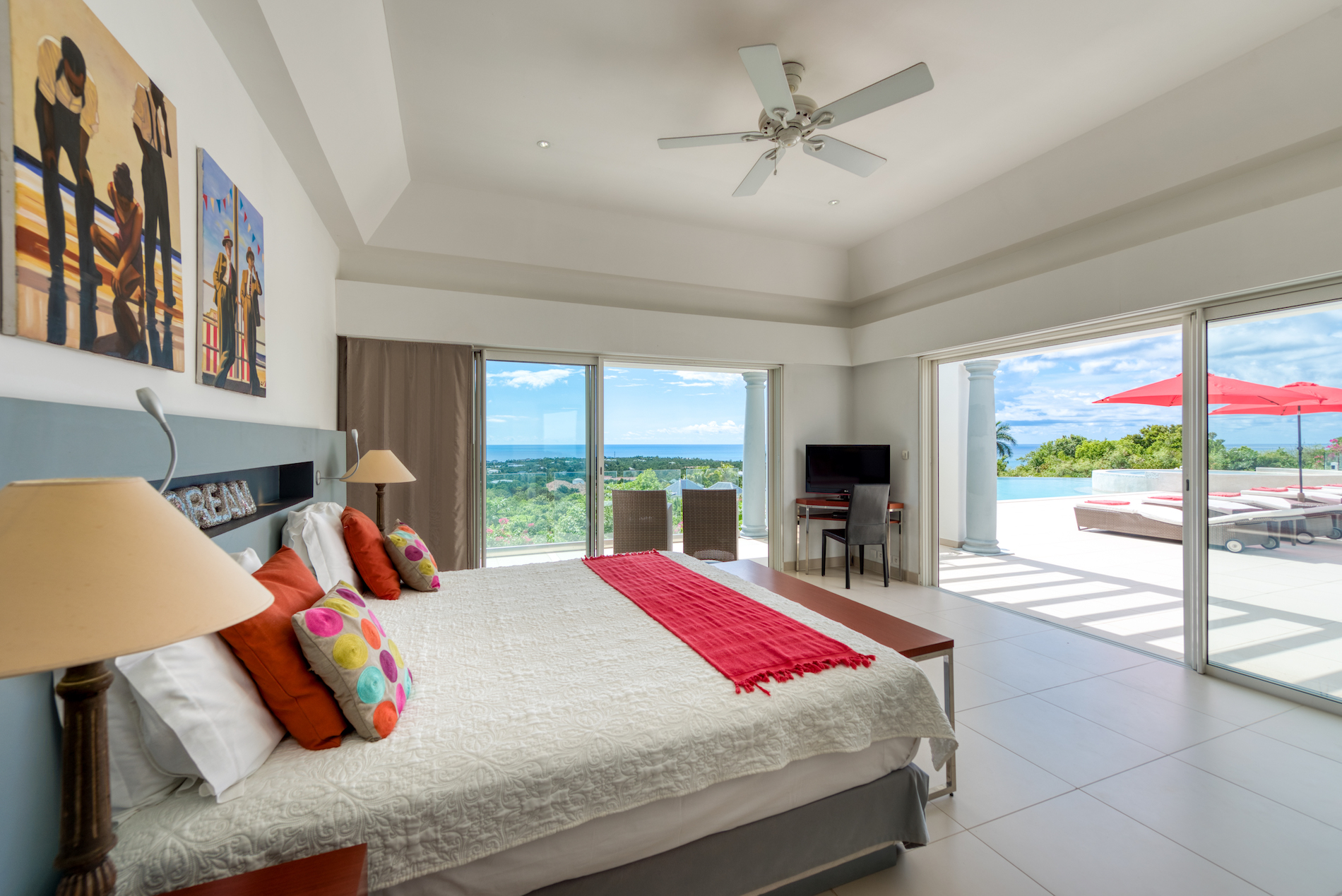 Red-accent bedroom with pool and sea views