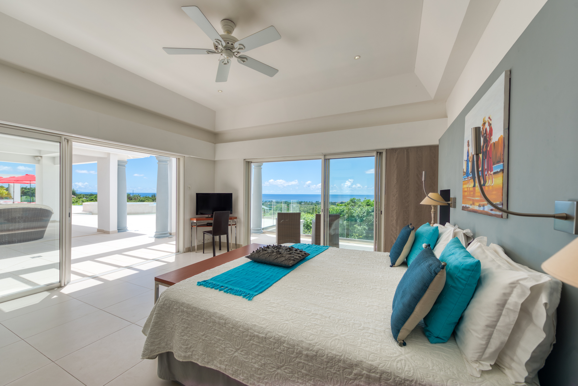 Turquoise-accent bedroom with pool and sea views